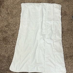 Crib pad. Thin and made of cotton and polyester.